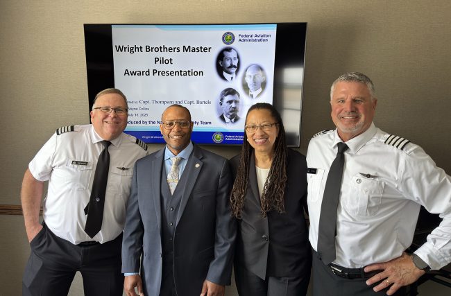 Jet Linx Pilots Bob Thompson (left) and Jeff Bartels (right) stand with Dwayne Collins, Aviation Safety Specialist, FAA and Luanne Wills-Merrell, Office Manager, Greater Chicago Flight Standards District Office, after receiving their Wright Brothers Master Pilot Awards in an intimate ceremony.