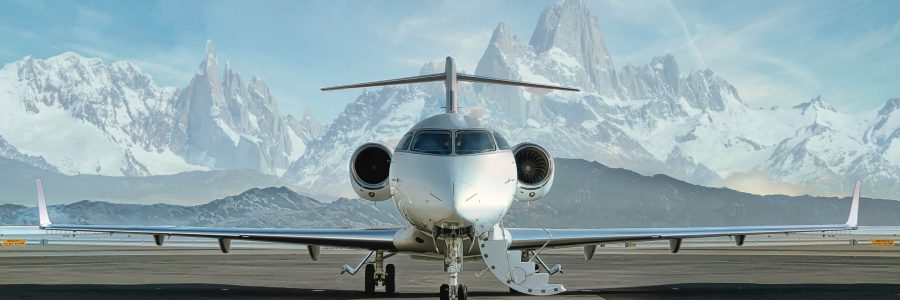 Head on photo of a private jet waiting on runway to be boarded with snowy mountains in the background